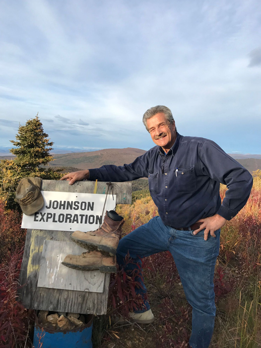Brian Johnson beside a Johnson Exploration marker in northern mining country